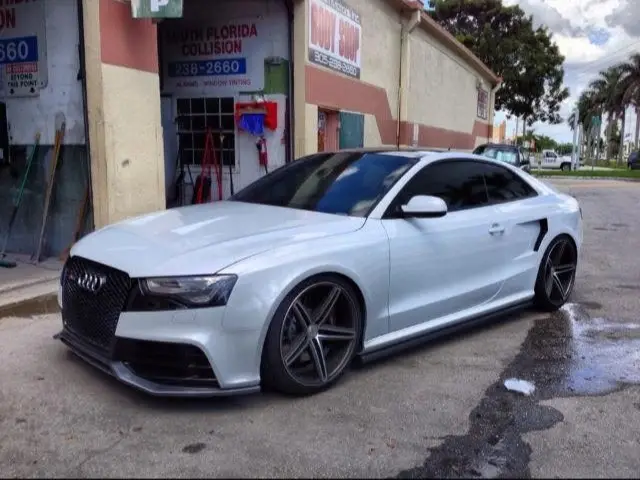 White Audi coupe parked outside the Marlin Motors body shop in Cutler Bay, FL