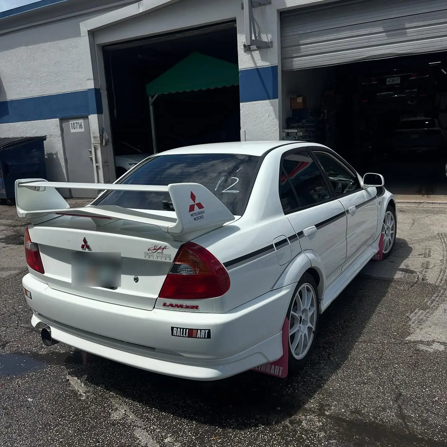White Mitsubishi Lancer Evolution VI with Ralliart mud flaps outside Marlin Motors in Cutler Bay, FL